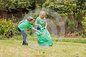 Happy siblings collecting rubbish