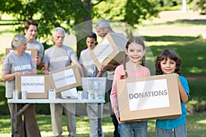 Happy siblings holding donation box