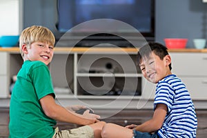 Happy siblings playing video games in living room