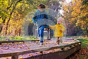 Happy siblings run and catch each other in park