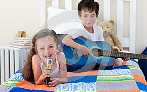 Happy Siblings singing and playing guitar