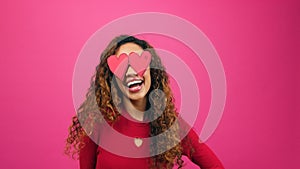 Happy silly woman poses with heart eyes, lovestruck infatuated emoji pink studio photo