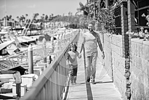 happy single daddy leading small son outside, fathering