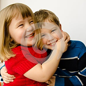 Happy sister and brother hugging each other