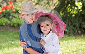 Happy sister and brother posing in the garden