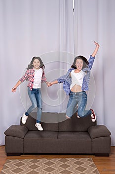 Happy sisters jump in freedom sense. mother and daughter having fun on weekend. move in new house. full of energy. real