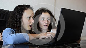 Happy sisters using laptop