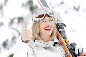 Happy skier with thumbs up in a slope
