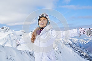 Happy skier woman on the background of snowy mountains