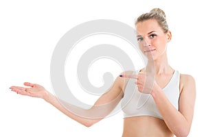 Happy slim girl showing something over white background