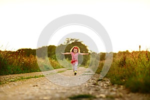 Happy small girl outdoor. Girl having fun in spring park. Blurred background in sunset