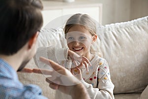 Happy small girl using sign language, communicating with father.