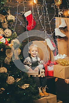 Happy small kids in santa hat with present have a christmas. Cute little child girl is decorating the Christmas tree
