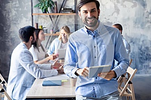 Happy smart business man with team mates discussing in the background.