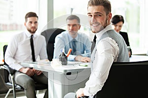 Happy smart business man with team mates discussing in the background