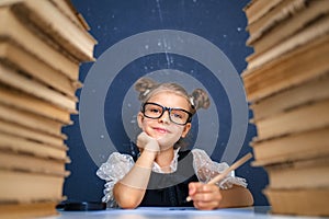 Happy smart girl in rounded glasses, holding a pencil in hand re