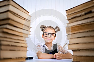 Happy smart girl in rounded glasses, holding a pencil in hand re