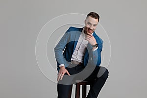 Happy smartcasual man holding elbow on thigh