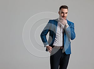Happy smartcasual model holding hand to chin