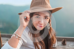 Happy smile asian woman hand holding hat with blur nature background, People lifestyle relaxing traveler