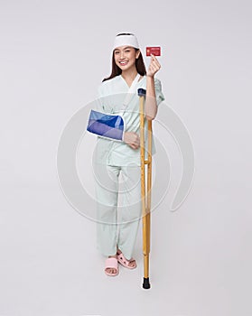 Happy smile asian woman patient put on a cast showing credit card isolated on white background. Healthcare services expenses,