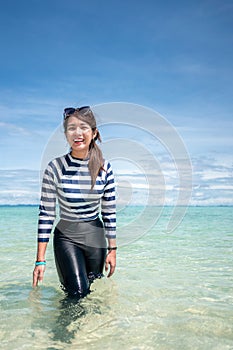 Happy smile Asian woman standing in sea water, Woman wear swimming suit, Travel vacation concept