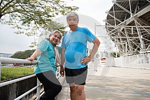 Happy and smile couples elderly asian standing on stairs for rest after workout, jogging on morning, senior exercise outdoor for
