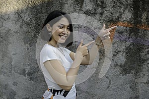 Happy and smile face with smile of young Asian girl with hand point on empty space