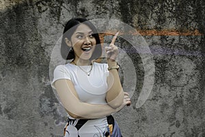 Happy and smile face with smile of young Asian girl with hand point on empty space