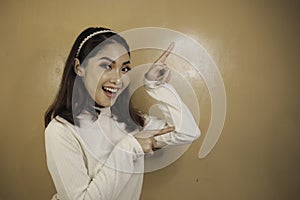 Happy and smile face with smile of young Asian girl with hand point on empty space