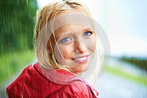 Happy, smile and young woman in the rain with coat in nature, road or street for winter. Portrait, positive attitude and