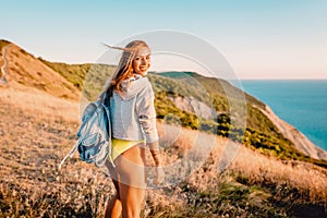 Happy smiled woman outdoor at warm sunset. Happy holiday in the mountains