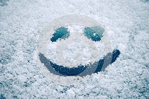 Happy smiley emoticon face in snow