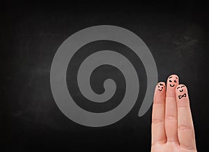 Happy smiley fingers looking at empty black chalboard