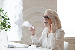 Happy smiling 60 years old businesswoman using laptop.