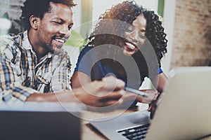 Happy smiling african american couple working together at home.Young black man and his girlfriend using laptop at home