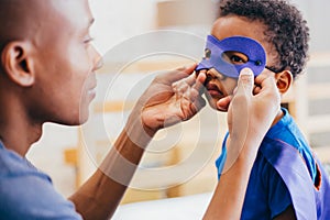 Happy smiling African American son being supported and helped by supportive father