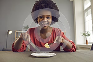 Happy smiling african american woman on diet eating apple looking at camera