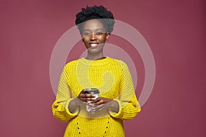 Happy smiling african american woman holding takeaway paper hot coffee tea cup, having break pause