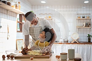 Happy Smiling African family  in Aprons Cooking and kneading dough on wooden table