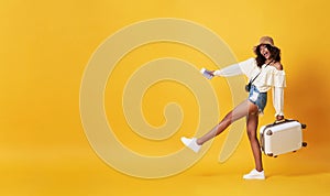 Happy smiling african woman dressed in summer clothes with luggage enjoying their summer vacation getaway in yellow banner