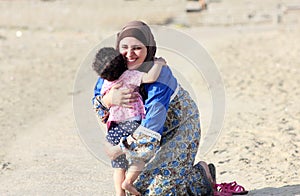 Happy smiling arab muslim mother hug her baby girl