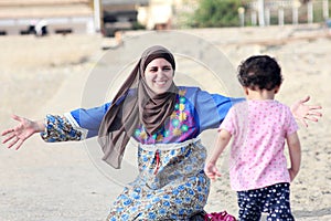 Happy smiling arab muslim mother hug her baby girl in egypt