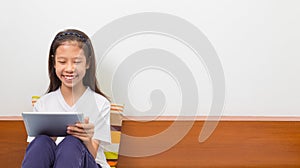 Happy smiling asian girl using computer tablet