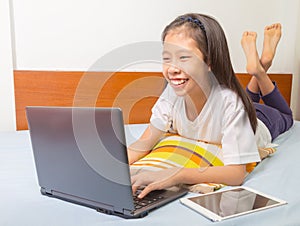 Happy smiling asian girl using computer tablet