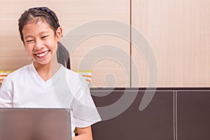 Happy smiling asian girl using notebook computer to study on her