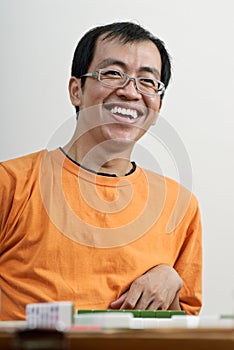 Happy smiling Asian man play Mahjong