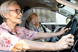 Happy smiling asian senior female driver in her car,enjoy traveling during retirement age with her friend,healthy old people