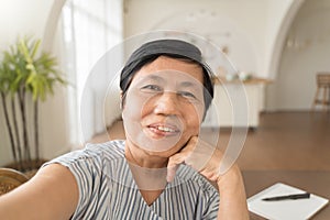 Happy smiling Asian senior woman using mobile phone taking selfie, Grandmother making video call on smatphone