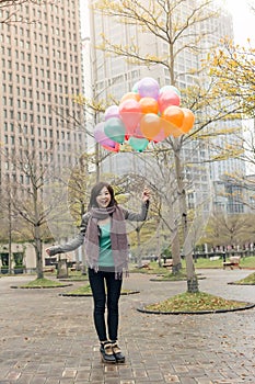 Happy smiling Asian woman holding balloons